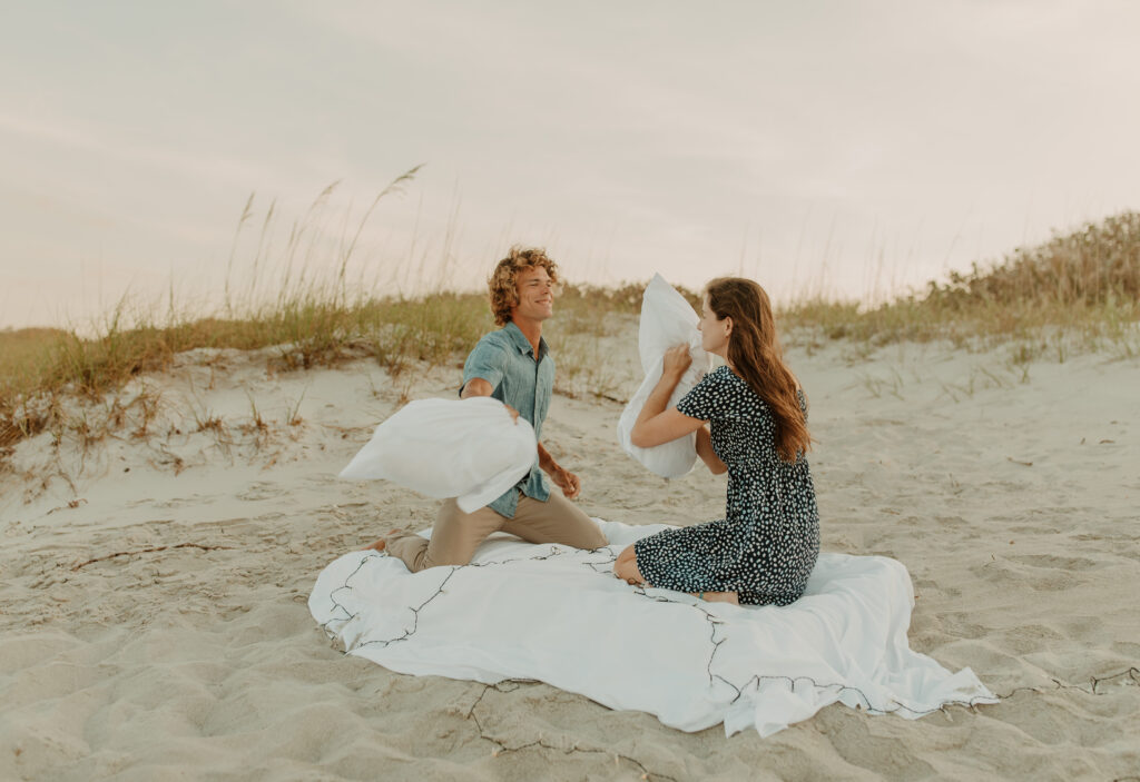 sunset engagement photo session with a pillow fight