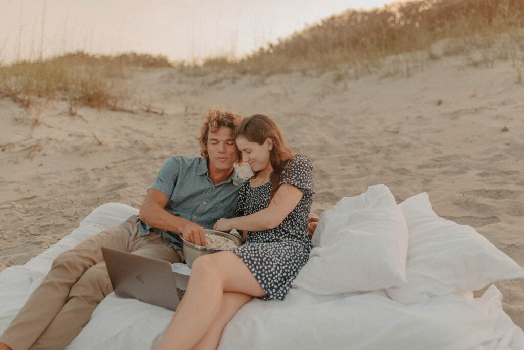 couple watching netflix on an air mattress on the beach